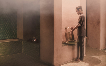 Wellness space at Amanjena with warm-toned walls and a guest accessing spa facilities.