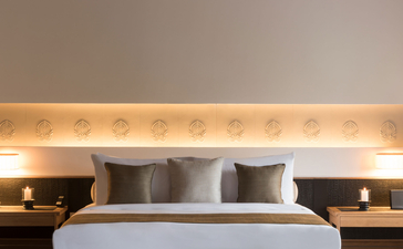 Principal bedroom at Amanoi with upholstered headboard and integrated lighting.