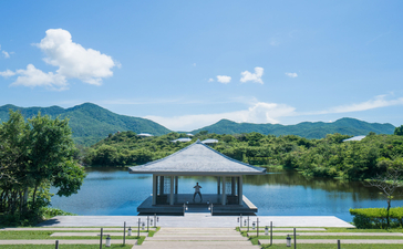 Amanoi's waterfront pavilion with mountain views across a reflecting pool.