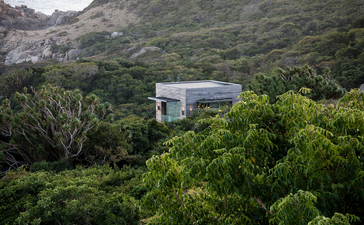Modern pavilion nestled amongst dense forest and coastal cliffs at Amanoi.