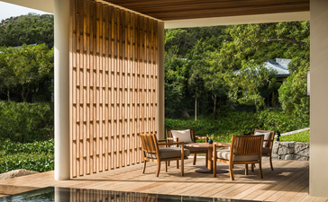 Wooden pavilion overlooking a plunge pool at Amanoi, with latticed screens and dining furniture nestled amongst verdant surroundings.