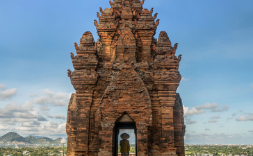 Ancient brick tower at Amanoi with clear blue sky and distant landscape beyond.