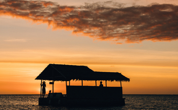 安缦璞乐度假村海上日落时分，木制船屋剪影。