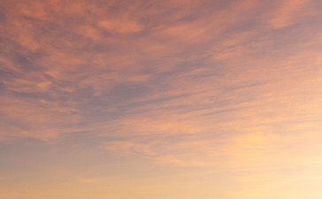 安缦璞乐度假村日落时分，平静水面倒映金黄色天空，远处岛屿轮廓清晰。