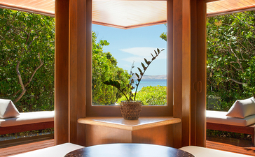 安缦璞乐度假村的木质餐厅，可饱览海景和绿色植被。