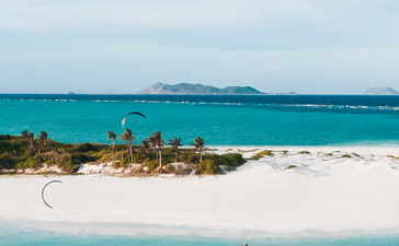 安缦璞乐度假村的白沙滩和绿松石色海水，远处可见岛屿。