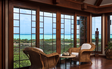 安缦璞乐度假村客房内，落地窗框景观远眺绿野田园风光。