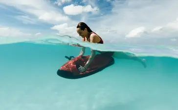 アマンプロ リゾートで、透き通った浅瀬でボートに乗る女性。