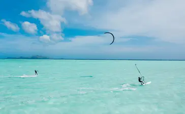 アマンプロ リゾートでのカイトサーフィン。ターコイズブルーの浅瀬で複数のカイトサーファーが風を受けている。
