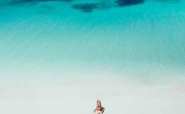 俯瞰图：客人在安缦璞乐度假村清澈的浅蓝色海水中游泳。