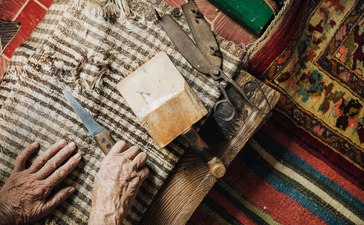 Overhead view of hands arranging fabric swatches and textile samples at Amanruya.