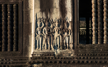 Stone carvings of figures adorning the exterior wall of Amansara's temple architecture.