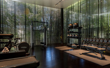 Wellness studio at Amansara with floor-to-ceiling windows, wooden floors, and yoga mats arranged for practice.