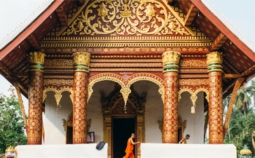 Golden temple entrance at Amantaka with ornate wooden doors and traditional Laotian architecture.