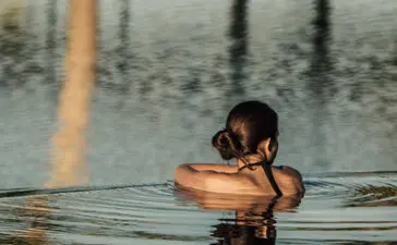 Guest swimming in a cenote at Amanvari, Mexico.