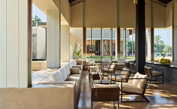 Amanwella dining venue with floor-to-ceiling windows overlooking coastal landscape.