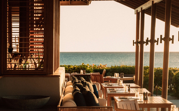Dining venue with wooden furnishings and ocean views at Amanyara resort.
