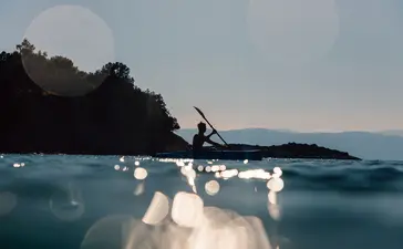 安缦卓熠度假村，旅客在晨光中划皮划艇，周围是平静的碧蓝海水。
