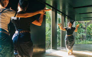Instructor guiding a dancer through a movement at Amansara.
