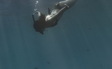 Snorkeller underwater near coral reef at Amankila resort, Bali.