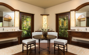 Baño de la habitación en el resort Amanpulo con tocadores de madera oscura y espejos iluminados.