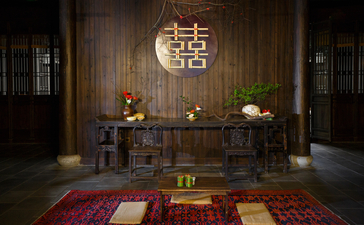 法云安缦度假村婚礼场地入口，木制门框装饰传统喜字，两侧摆放花卉。