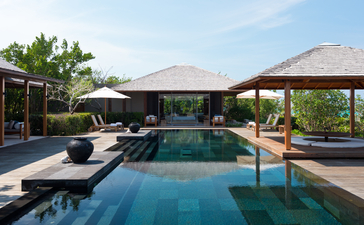 Four-bedroom ocean villa at Amanyara with infinity pool, sun loungers and thatched pavilions.