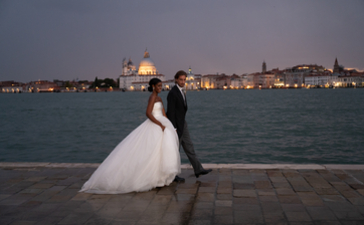 新娘和新郎在安缦威尼斯酒店面向水道拥抱，背景为圣马可大教堂。