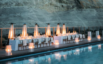 Candlelit wedding setup reflected in still water at Amangiri, with red rock cliff backdrop.