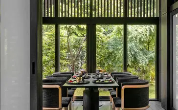 Taka-an private dining room at Aman Kyoto resort, with shoji screens framing garden views and a minimalist table setting.