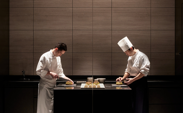 Two chefs at work in La Pâtisserie at Aman Tokyo, preparing pastries with precision and focus.