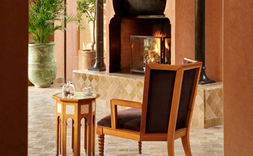 Al Hamra Maison seating area with terracotta walls and traditional Moroccan architectural details at Amanjena.
