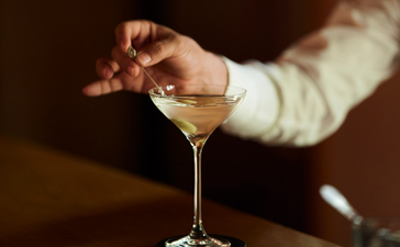 手持马提尼酒杯，安缦珍纳度假村的调酒师准备供应饮品。