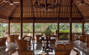 Amandari resort's bar with wooden ceiling structure, comfortable seating, and views of surrounding landscape.