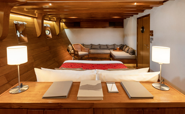Deluxe cabin interior at Amandira with wooden furnishings, workspace, and bedroom area beyond.