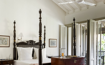 Principal bedroom at Amangalla with four-poster bed and ceiling fan.