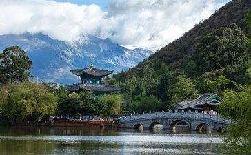 Black Dragon Pool reflects snow-capped mountains and traditional architecture at Amandayan, Lijiang.