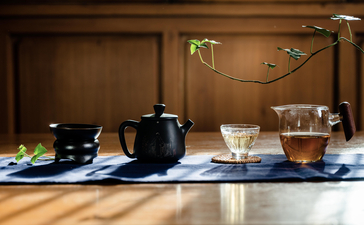 Traditional Chinese tea ceremony setup at Amandayan with ceramic teapot, cups, and brewing vessels on wooden table.