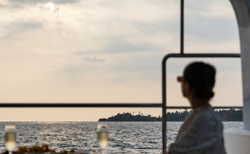 Guest gazing towards coastal views from inside a boat at Amangalla.