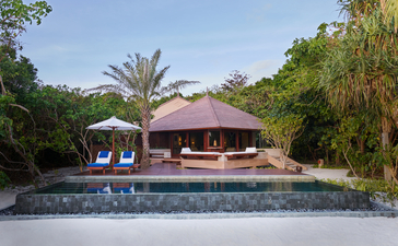 Beach Pool Casita at Amanpulo with thatched-roof pavilion overlooking tropical waters and lush gardens.