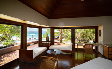 Beach Pool Casita bedroom at Amanpulo with expansive windows overlooking tropical gardens and ocean views.