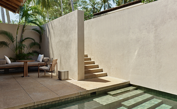 Amanwella suite courtyard with stone steps, planted urns, and minimalist walls in Sri Lanka.
