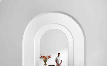 Ben Richards photograph of a vaulted corridor at Amangalla with a piano and wooden chairs visible through the archway.
