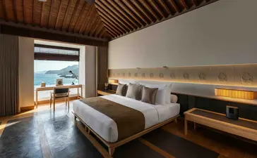 One-bedroom ocean pool residence at Amanoi with bed overlooking coastal waters and terrace.