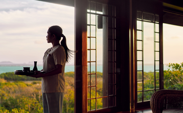 安缦璞乐度假村水疗中心，一位访客站在落地窗前眺望菲律宾海景。