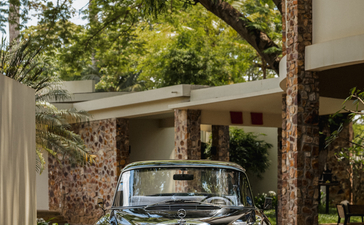 Vintage car parked beneath a shaded pergola at Amansara, Cambodia.