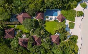 Widok z lotu ptaka na wille otoczone zielenią i drogą na terenie kurortu Amanpulo.