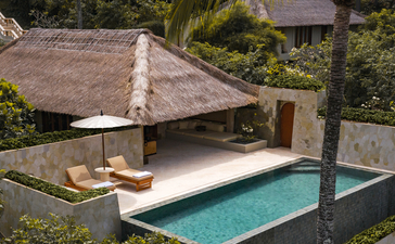 Infinity pool suite with thatched pavilion at Amankila resort, surrounded by tropical gardens.