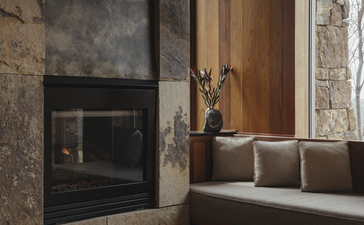 Amangani suite with fireplace and seating area overlooking mountain landscape.