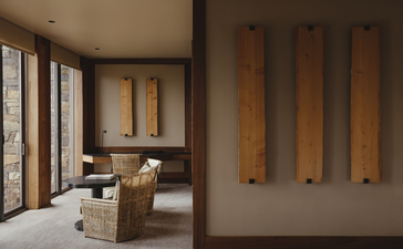 Amangani suite with wooden architectural details and floor-to-ceiling windows overlooking natural landscape.